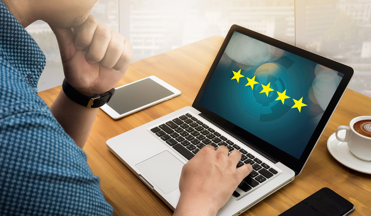 Businessman looking at 5 star rated services website Businessman looking at 5 star rated services website